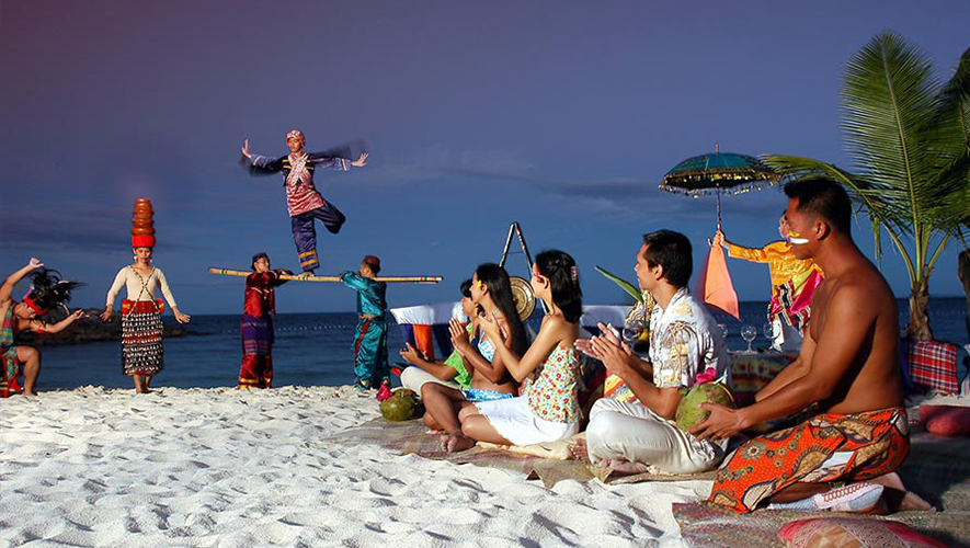 Folks in tribal dance as tourists watch on